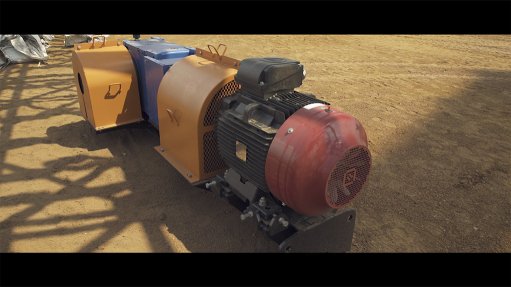 A large electric motor sat on the ground sealed in an orange corrosion proof and fire retardant paint at a mine in Africa