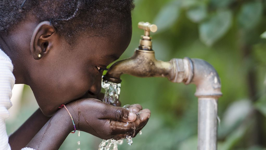 Child drinking water from a tap