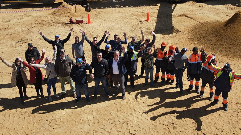 A group of men and women in PPE stood in front of the machinery supplied to Jongiliziwe sand mine by ELB Equipment