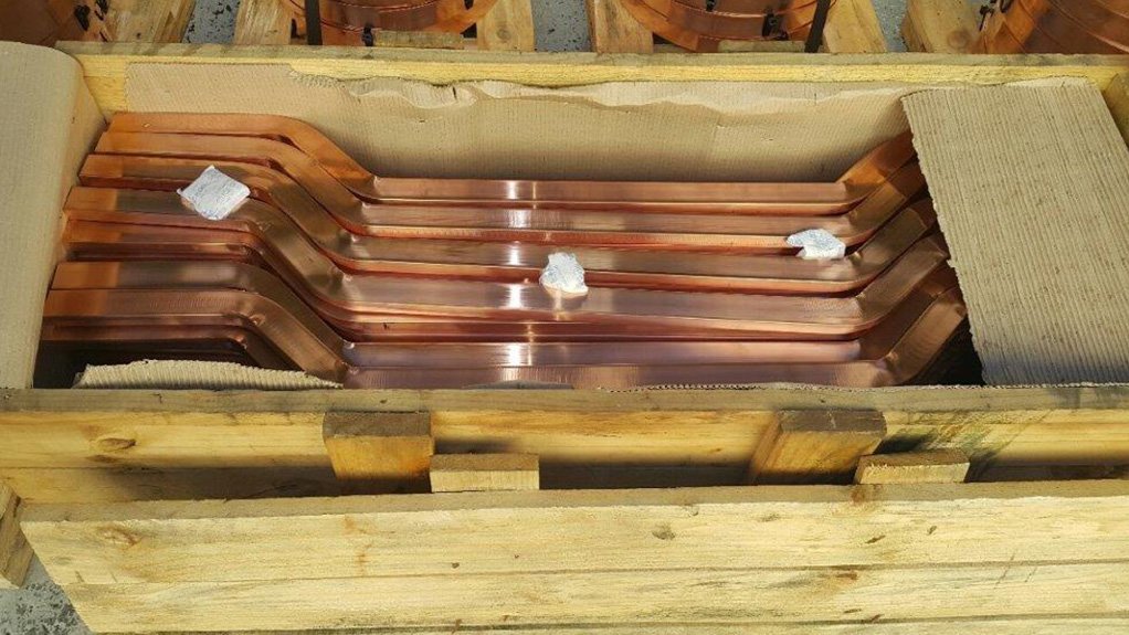 A large box of processed copper hangbars for a client