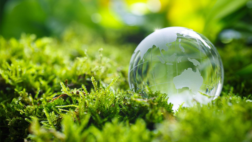 A glass glob perched on green moss signifying a global drive to a greener economy