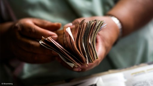 A person holding a stack of banknotes