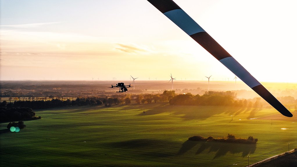 Image of a drone with wind turbines in background