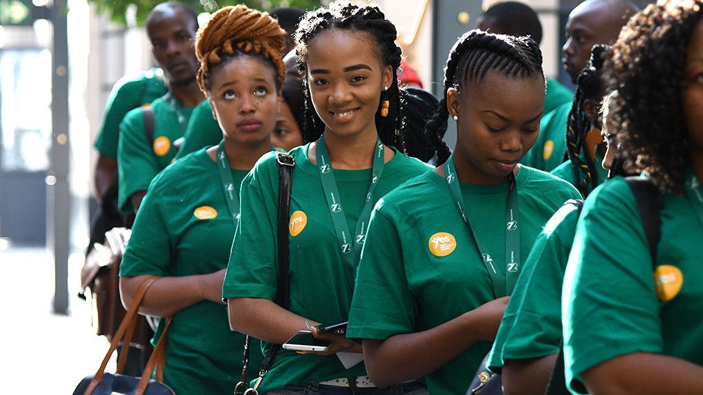 a group of women one smiling straight at the camera wearing green Youth Employment Programme shirts