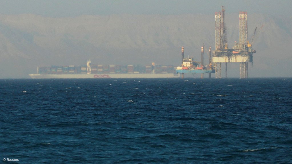 A container ship passing an oil platform near the Suez Canal