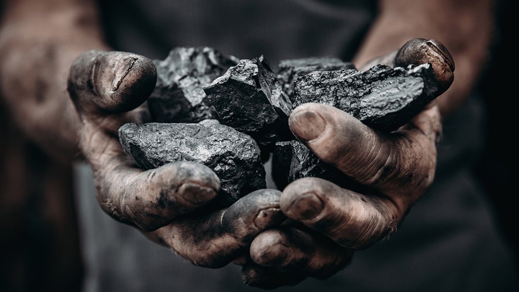 Two hands holding raw coal
