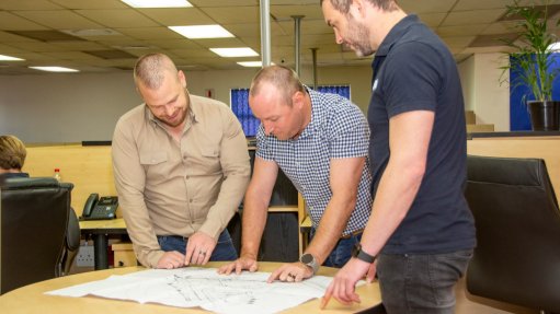 The above image depicts the team at Weba Chute Systems discussing a design