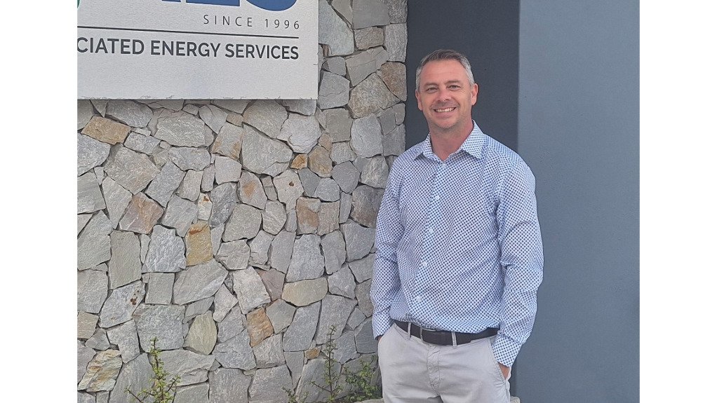 AES operations associate director Ray Lund  standing in front of a company sign for AES