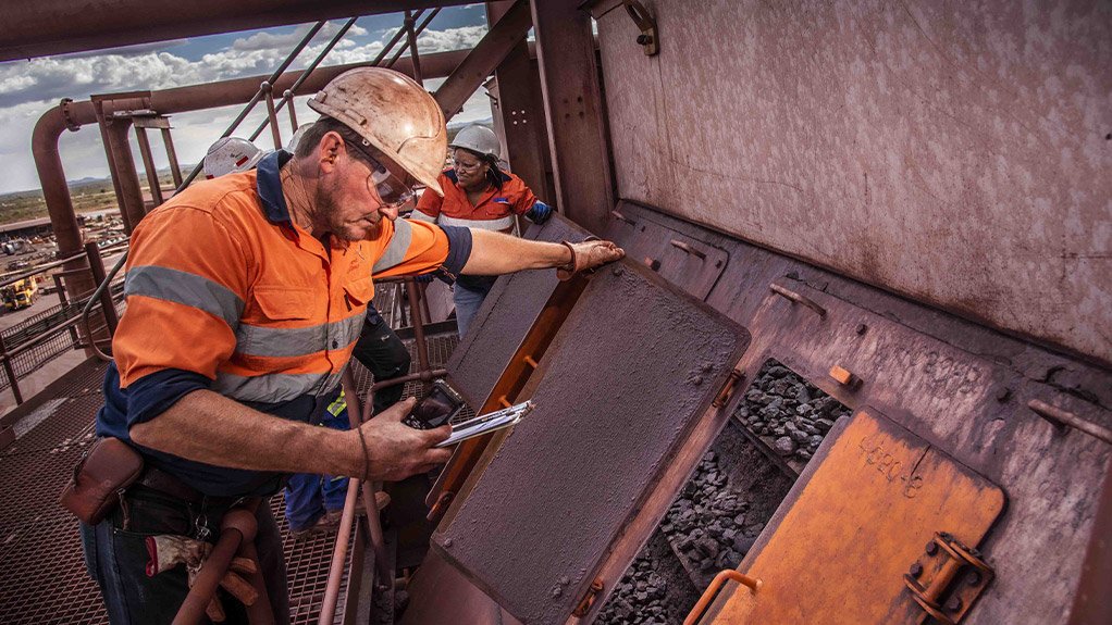 Weba Chute systems field advisor doing an inspection on a chute, noting the wear pattern