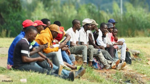 Job seekers waiting for casual work next to a road in Johannesburg