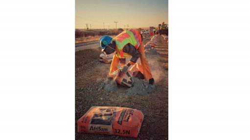 The above image depicts a worker, making use of the Afrisam Roadstab Cement