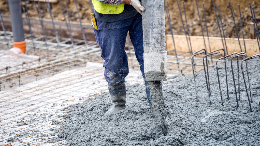 The above image depicts a worker pouring cement 