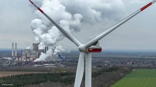 A wind turbine and a fossil fuel-powered plant