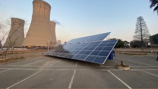 Solar panels in front of Komati power station cooling towers