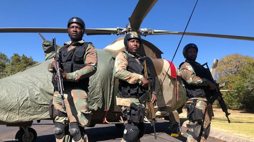 soldiers in front of helicopter