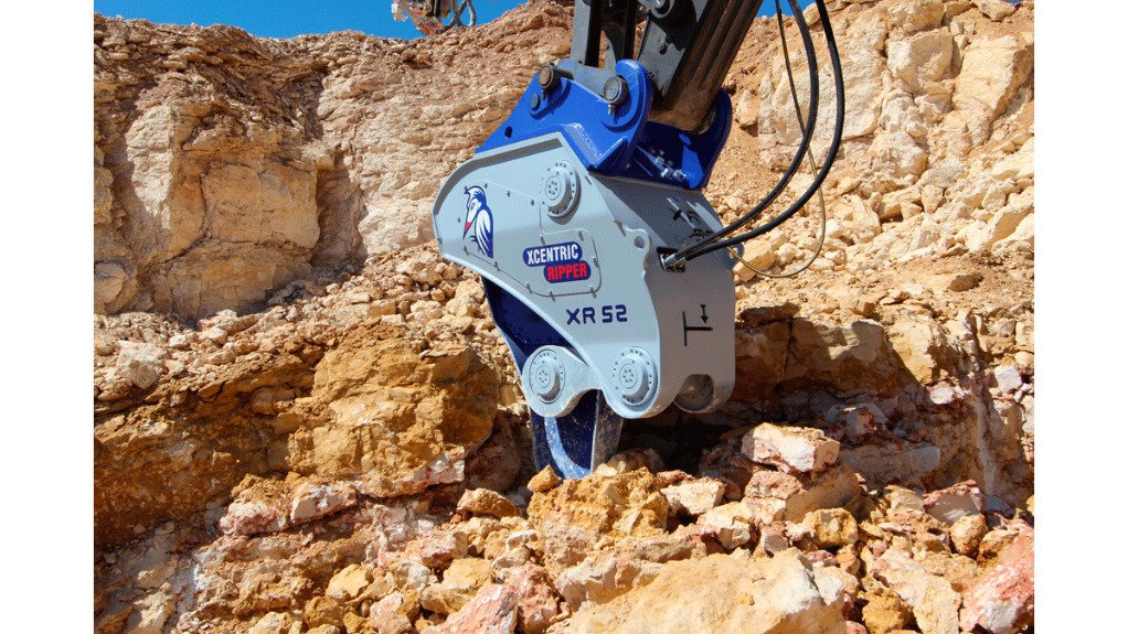A brand new blue Xcentric hydraulic ripper excavator attachment on the ground situated at a mine operation