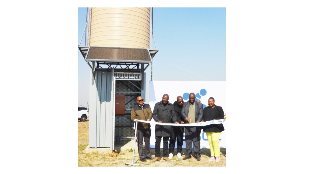 An image of the Sasol staff personnel standing next to a borehole