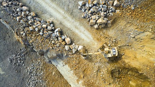 An image of a surface mining site being worked by an excavator 