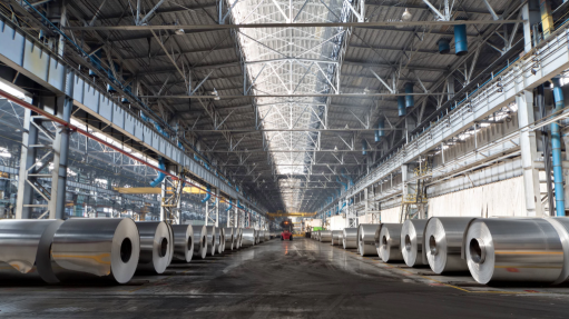 A large factory setting with aluminium rolls and vehicles in it