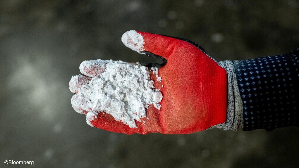 A gloved hand holding lithium