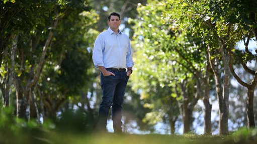 Rio Tinto chief decarbonisation officer Jonathon McCarthy standing among Pongamia trees.