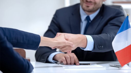 Handshake next to French flag