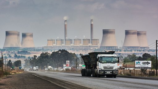 A coal truck driving away from a power station