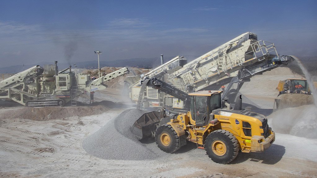 Stockpiles of crushed aggregates being produced using the Metso train are loaded and hauled