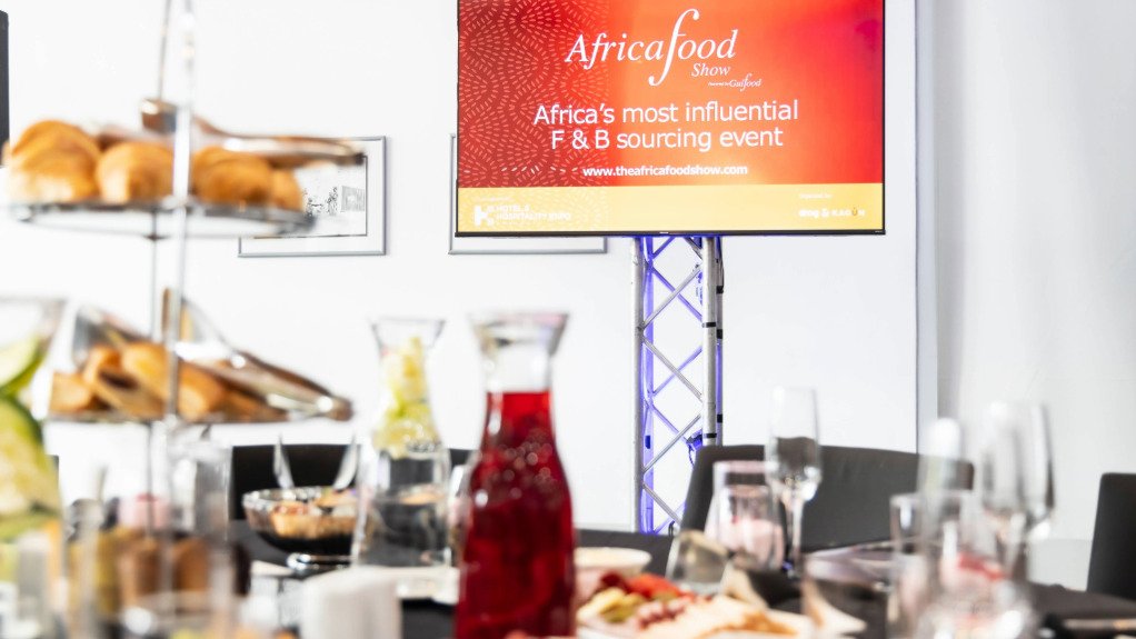 The above image depicts a grazing table with a screen depicting the event in the background. 