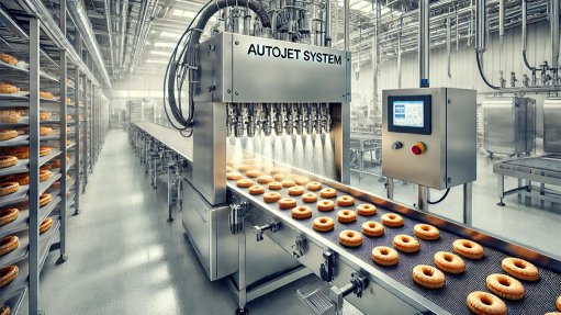 An industrial automated AutoJet System in a food processing facility, showcasing its use in applying precise coatings to baked goods.