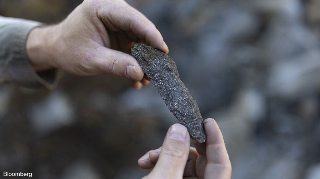 Hands holding a shard of graphite