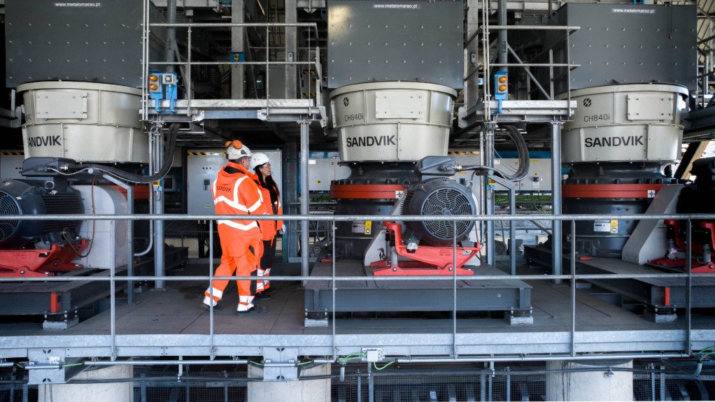 Two people standing on a platform with Sandvik crushers and technology being assessed