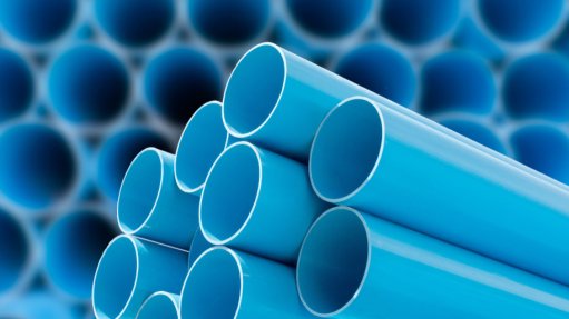 A group of bright blue plastic pipes lined up together 