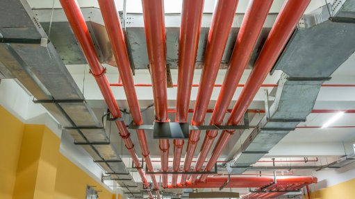 A row of bright red pipes installed in the roof of a building