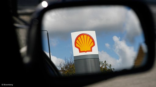 Sign with a Shell logo reflected in the mirror of a car