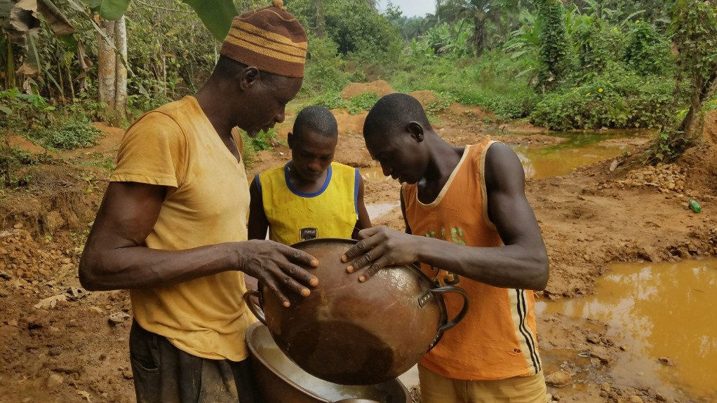 The above image depicts 3 artisinal miners extracting gold