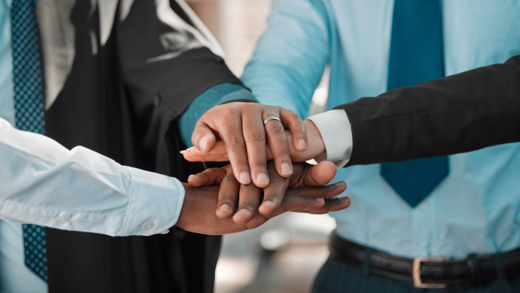 An image of a team putting their hands together for collaboration 