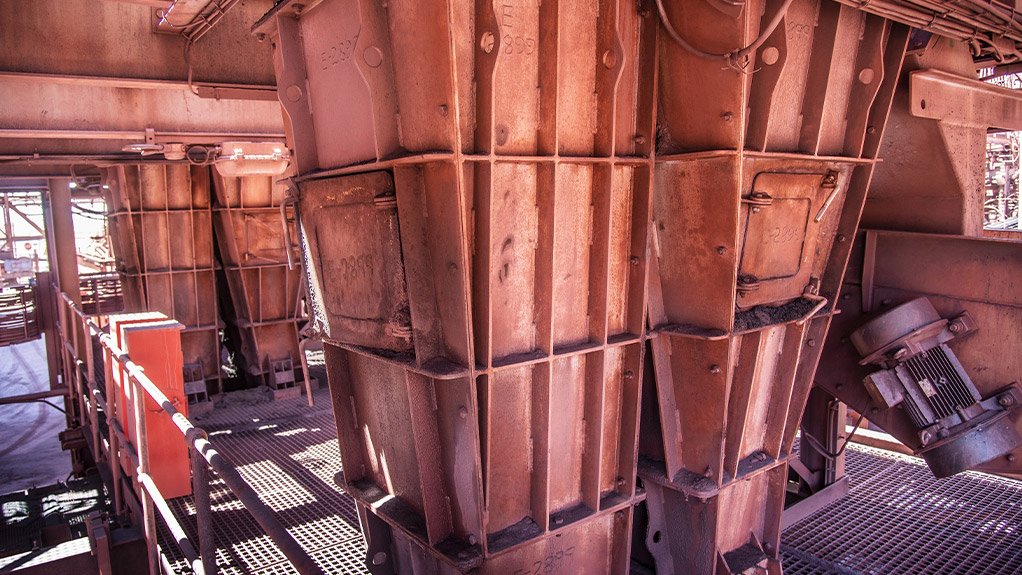 The feed conveyor discharge chute at an iron ore mine is designed for seamless material transfer, reducing spillage and dust while improving efficiency