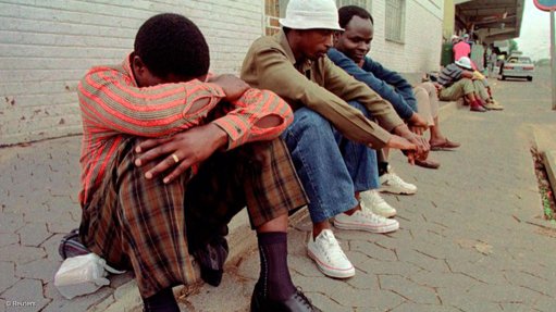 People waiting on a curb for casual work opportunities