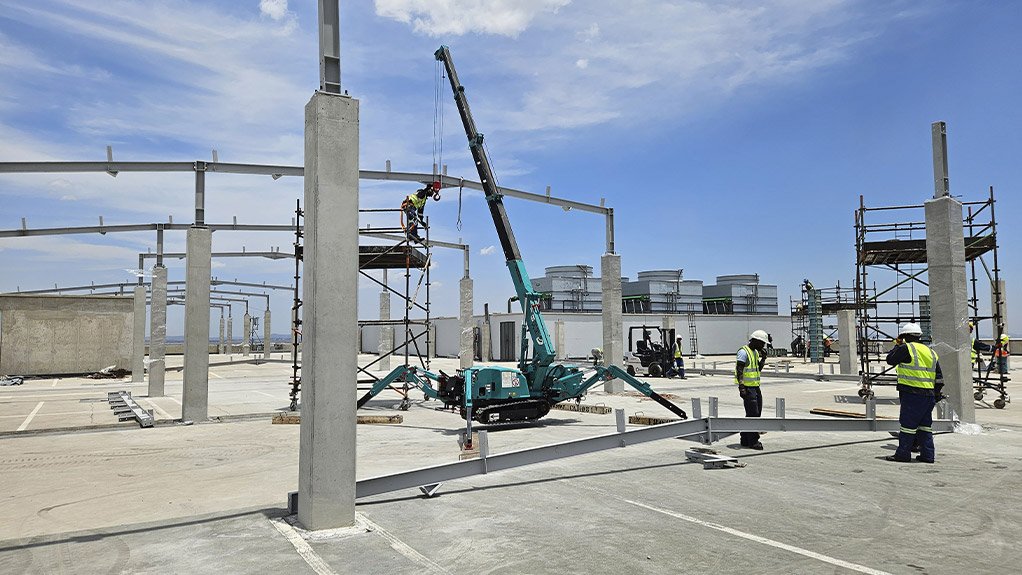 Lightweight construction methods are used due to load restrictions on the rooftop, with spider cranes and dumpers used for erection activities