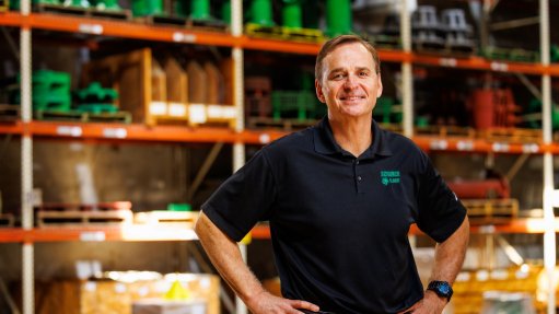 a photo of Nicholas Schur owner of Schurco Slurry in front of shelves packed wit Schurco Pumps
