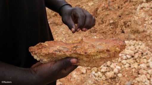 A man holding a piece of gold ore which has been mines illegally in ghana