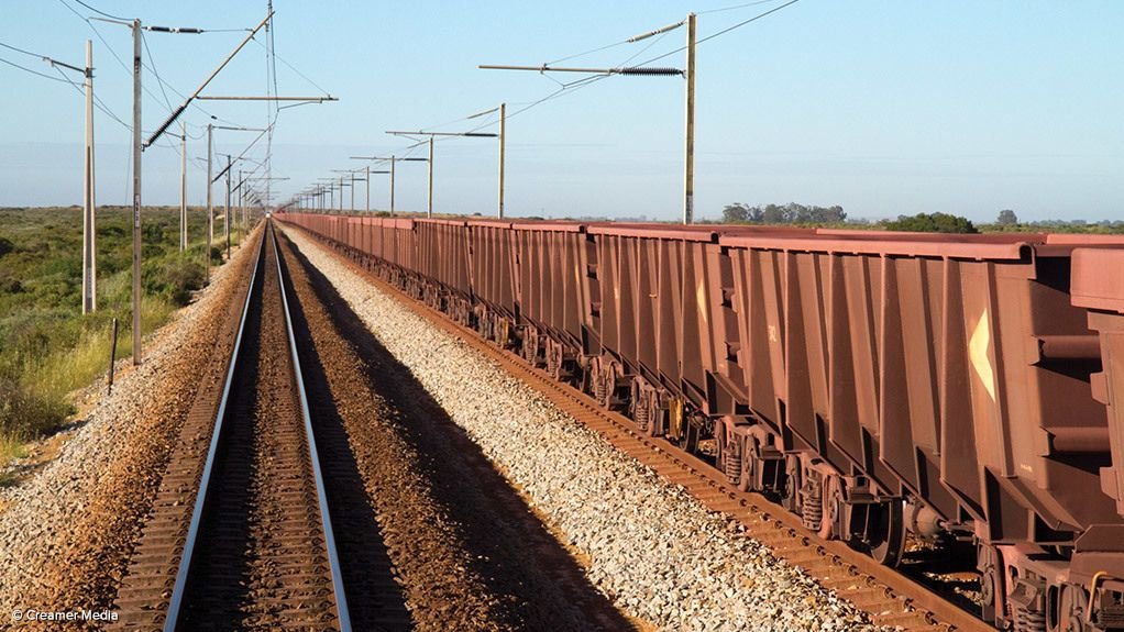 Train tracks on dry, rocky ground.