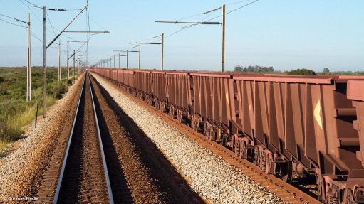 Train tracks on dry, rocky ground. 