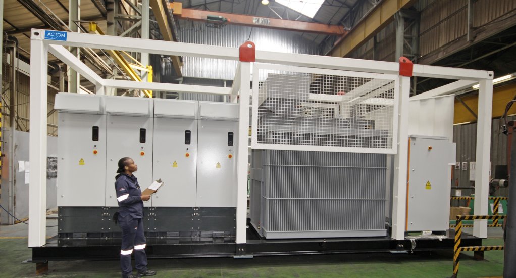 A lady with a clipboard in front of the integrated solar inverter and transformer developed by Actom in conjunction with Sungrow