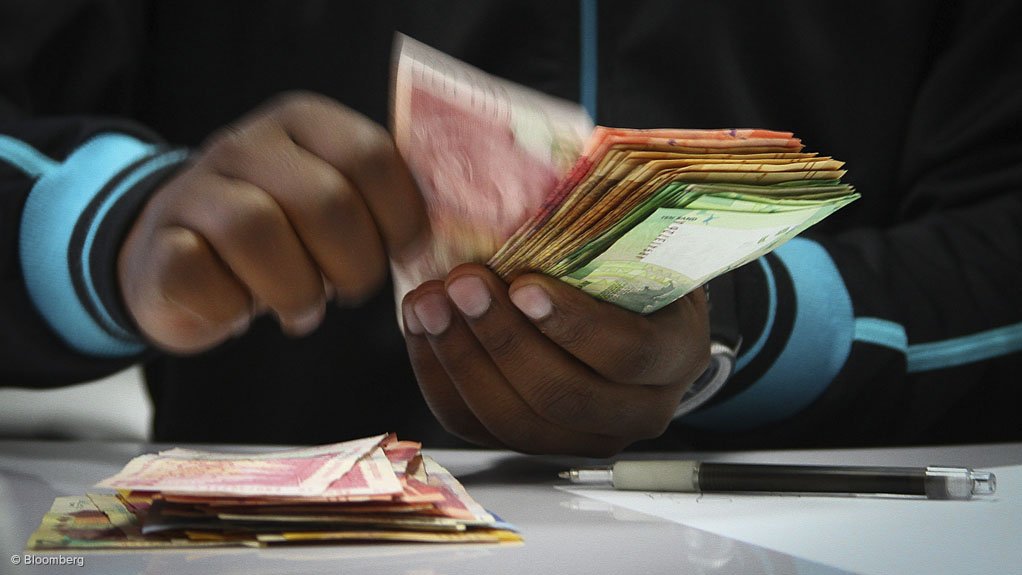 Person handling South African banknotes