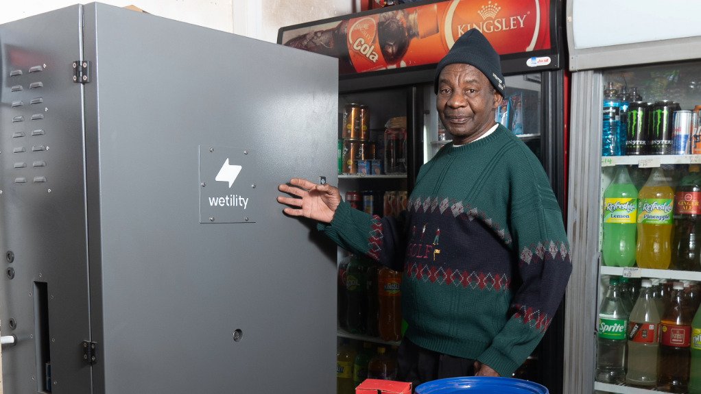 Lebohang a spaza shop owner in Katlehong in front of his LUXE system