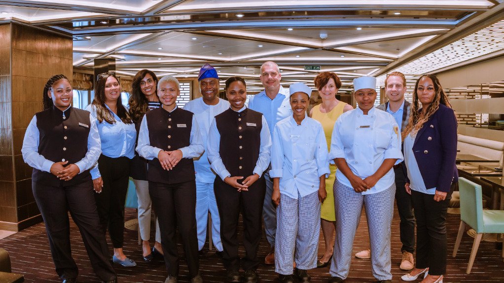 A group of chefs, waitrons and cleaners as well as executives on a cruise liner ready to serve guests