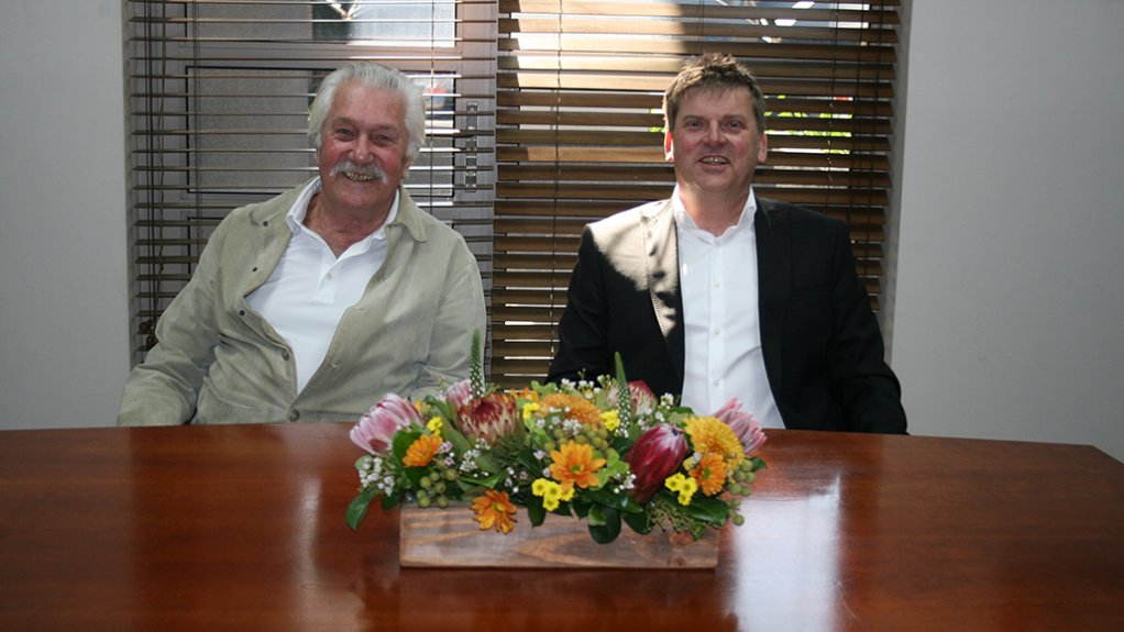 Men sitting at table, smiling