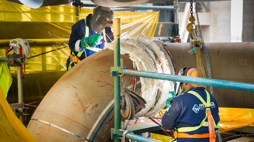 Artisans welding industrial pipe